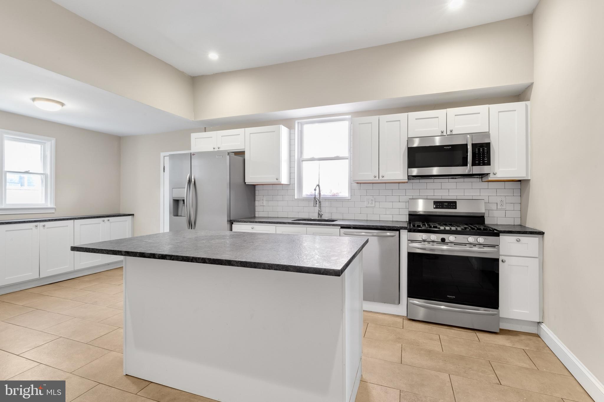 a kitchen with stainless steel appliances granite countertop a sink and a stove