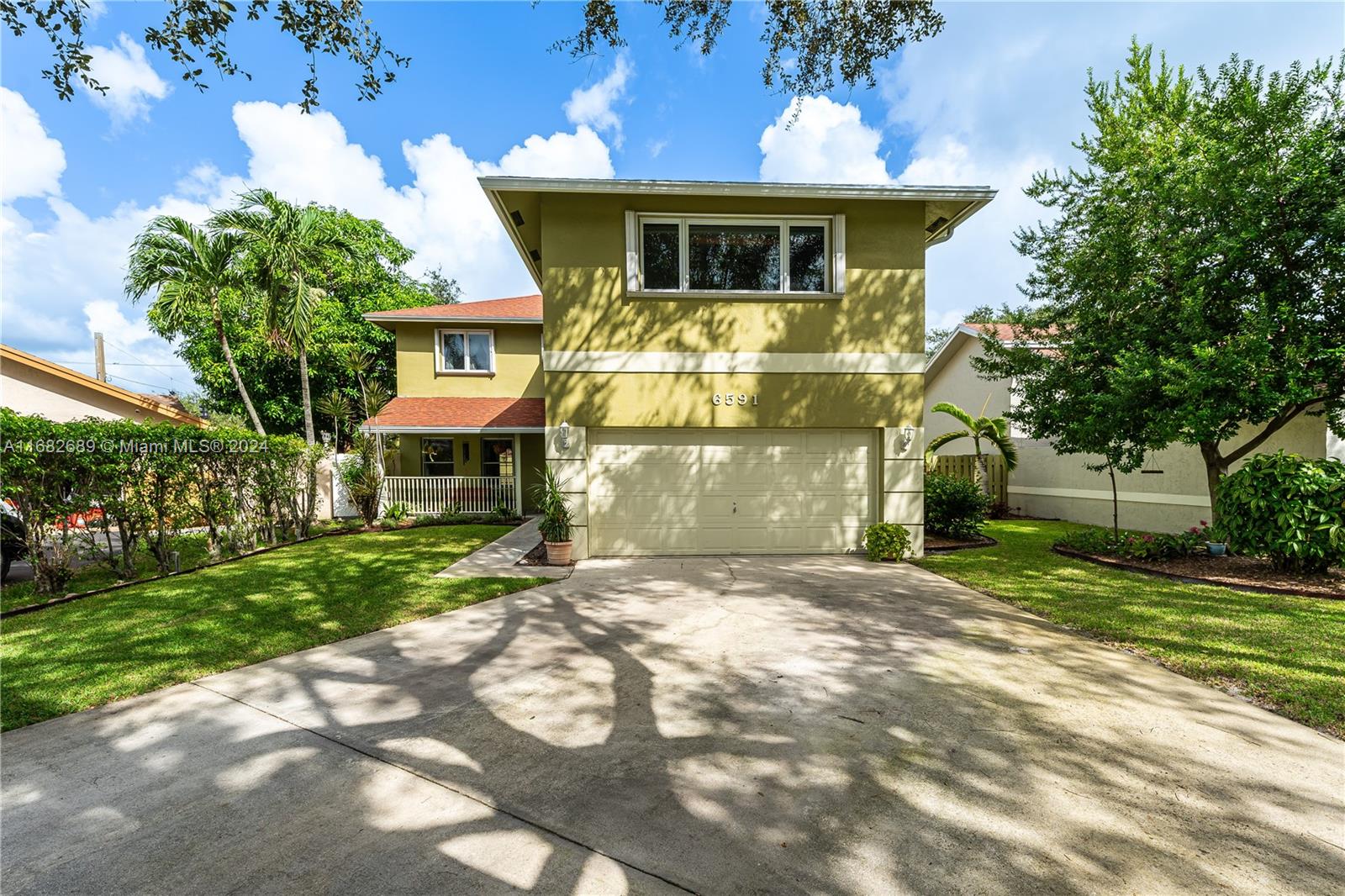 a front view of a house with a yard and a garage