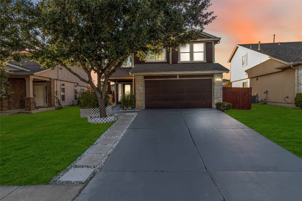 a front view of a house with a yard and garage