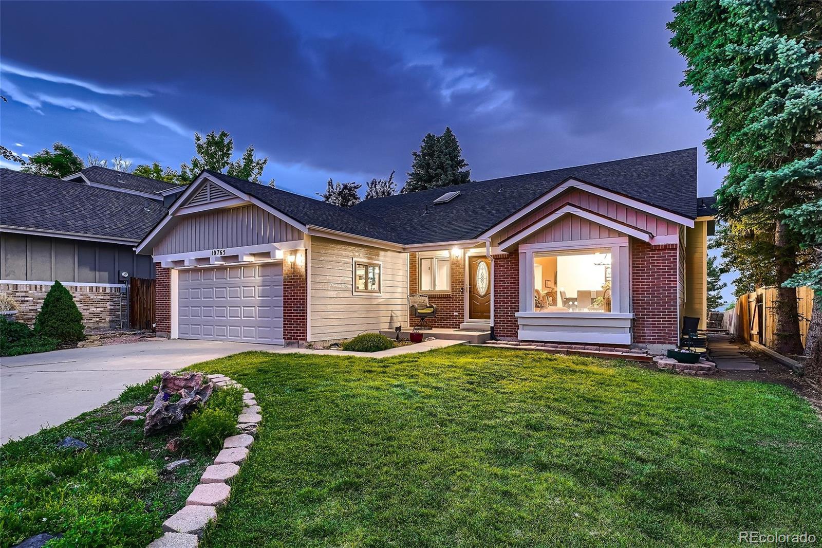 a front view of a house with a big yard and a large tree