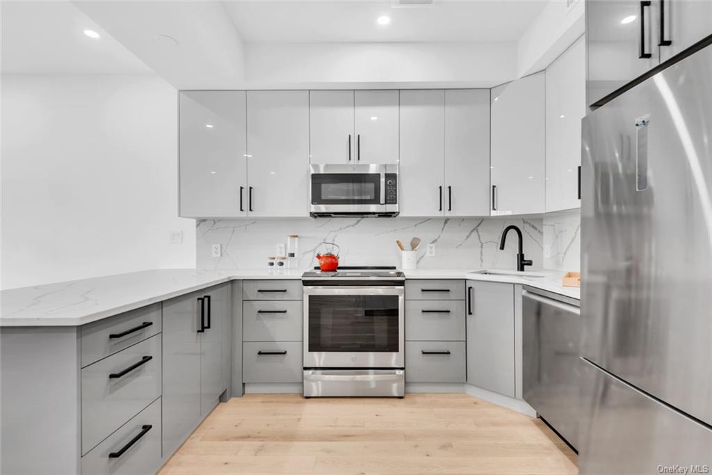 a kitchen with stainless steel appliances a stove sink and cabinets