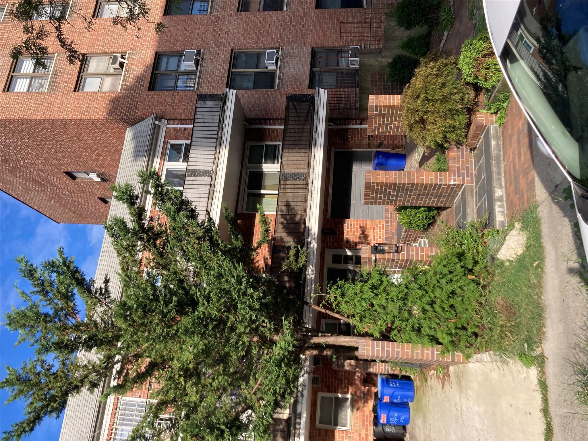 a front view of a house with a yard and plants