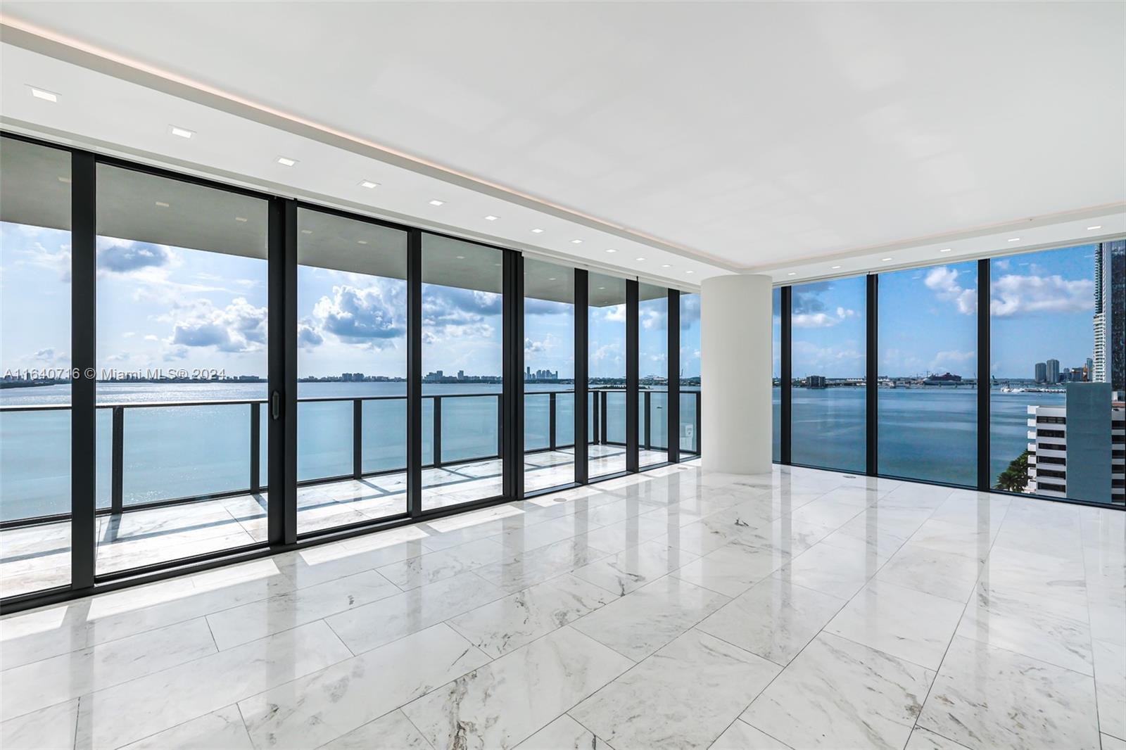 a view of an empty room with a balcony and floor to ceiling window