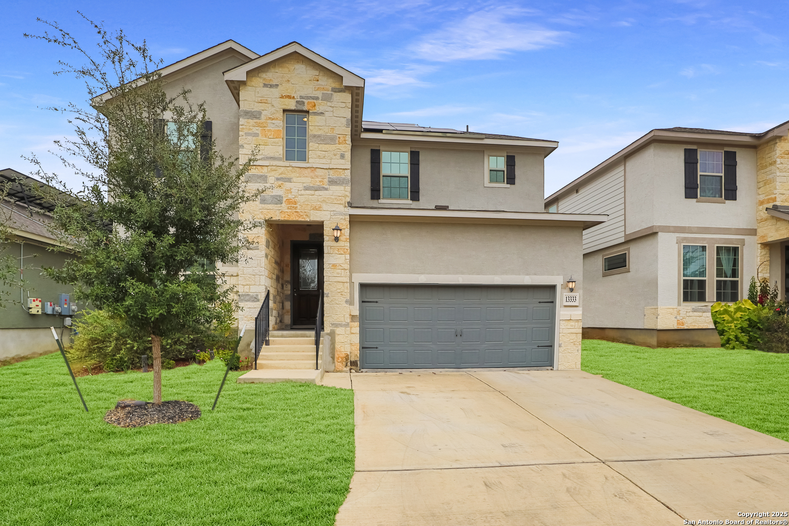 a front view of a house with a yard and garage