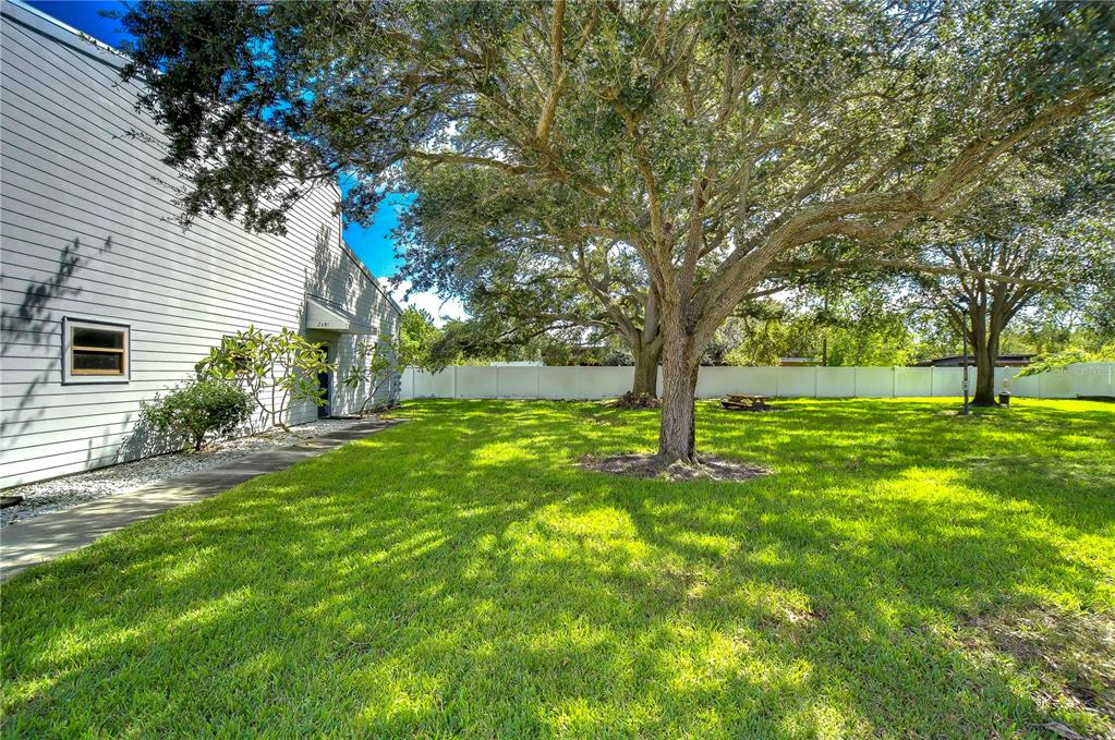 a view of yard with green space and trees