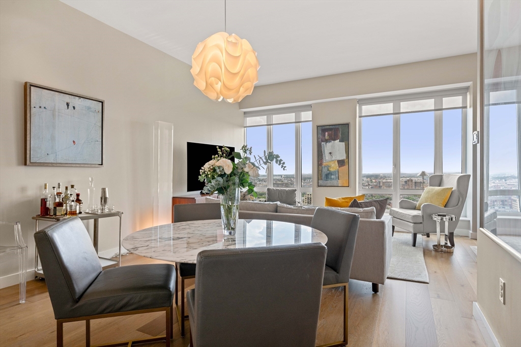 a dining room with furniture a large window and a chandelier