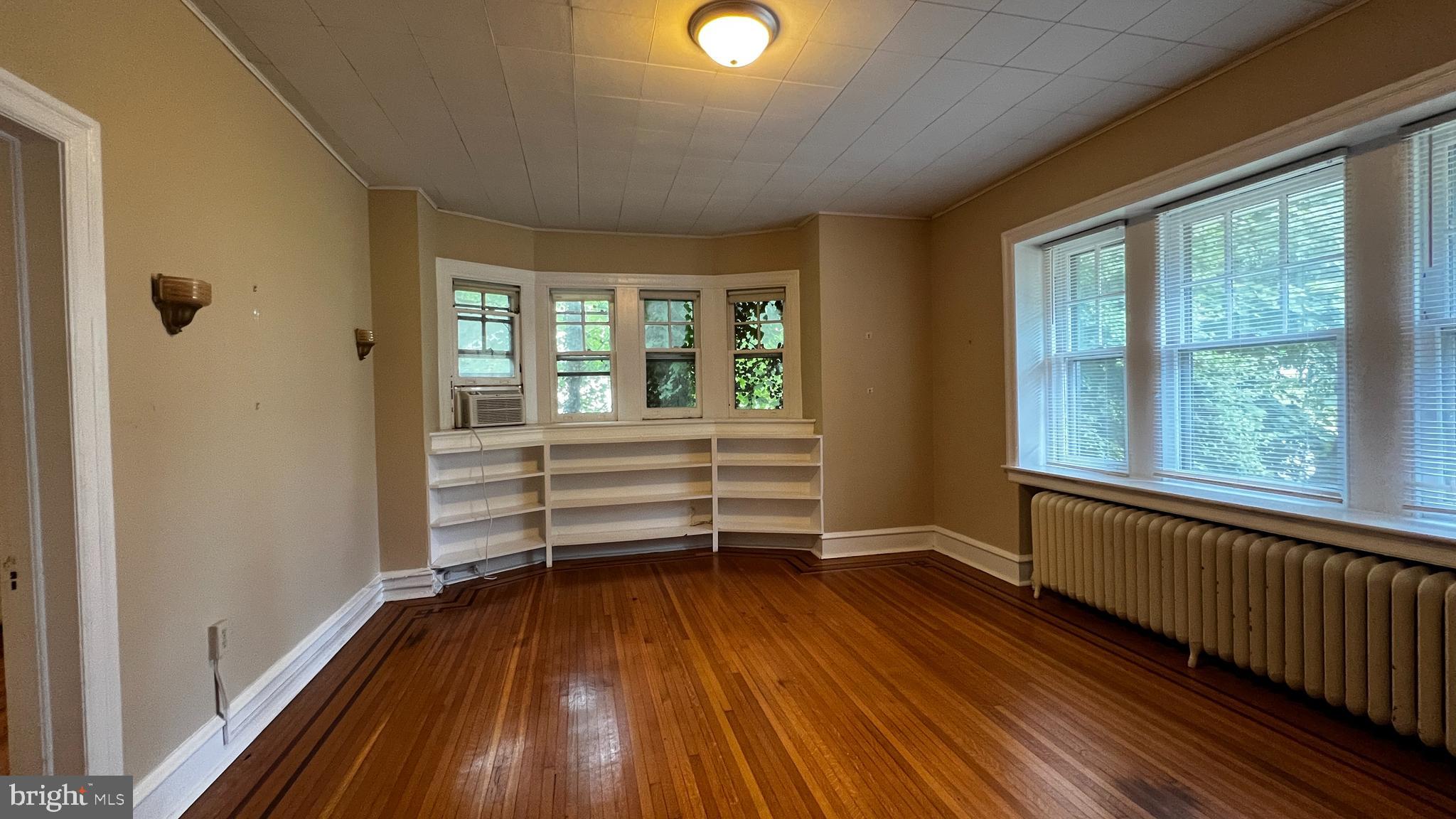 a view of a room with wooden floor and windows