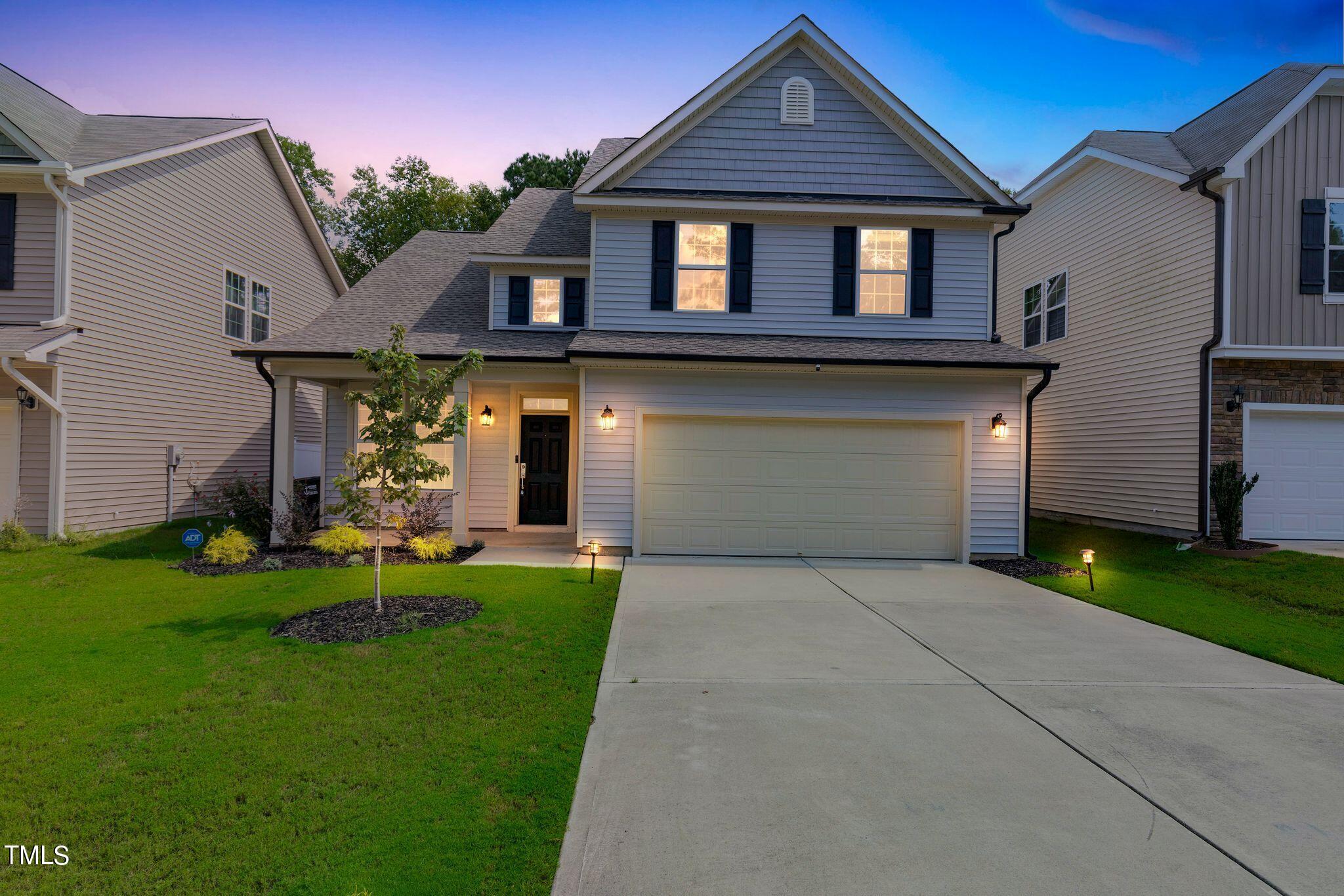 a front view of a house with a yard and garage