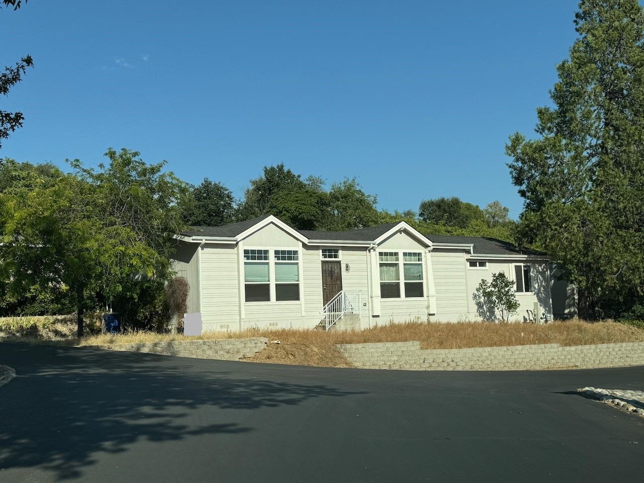 a front view of a house with a garden and yard