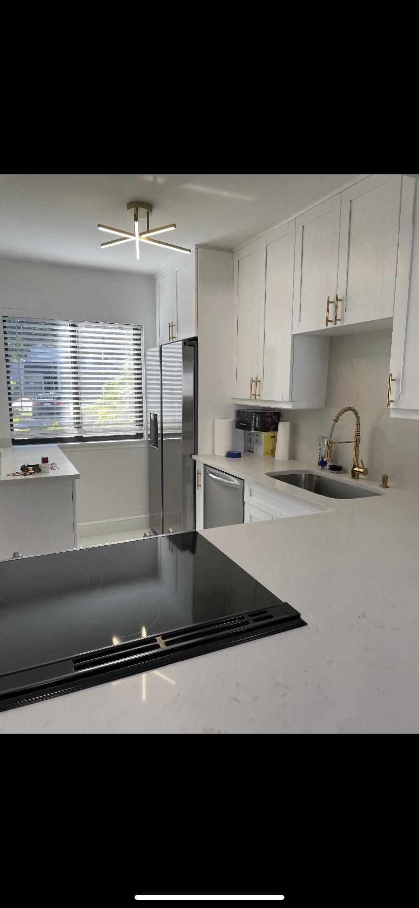 a kitchen with kitchen island a sink a stove and white cabinets