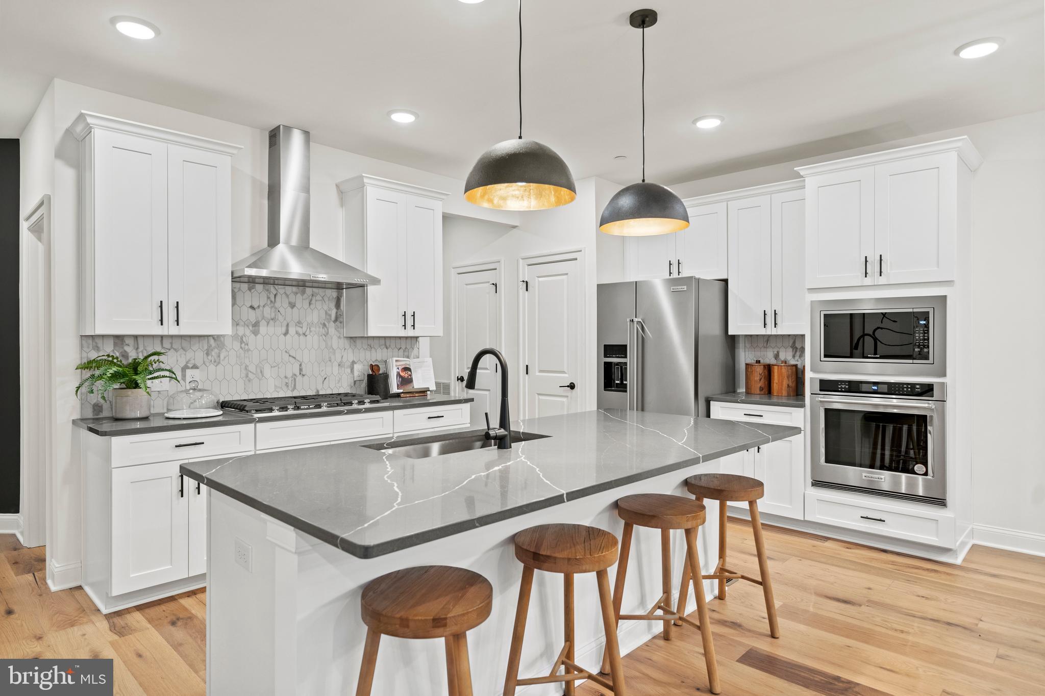 a kitchen with stainless steel appliances granite countertop a stove a sink and a refrigerator