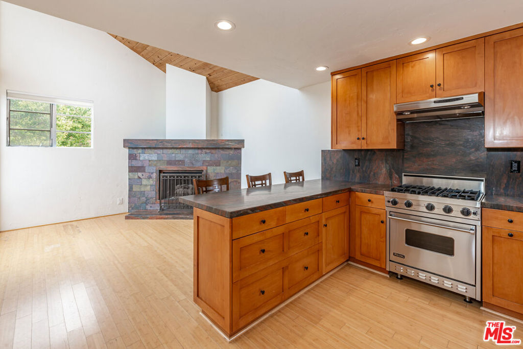 a kitchen with stainless steel appliances granite countertop a stove a sink and a microwave