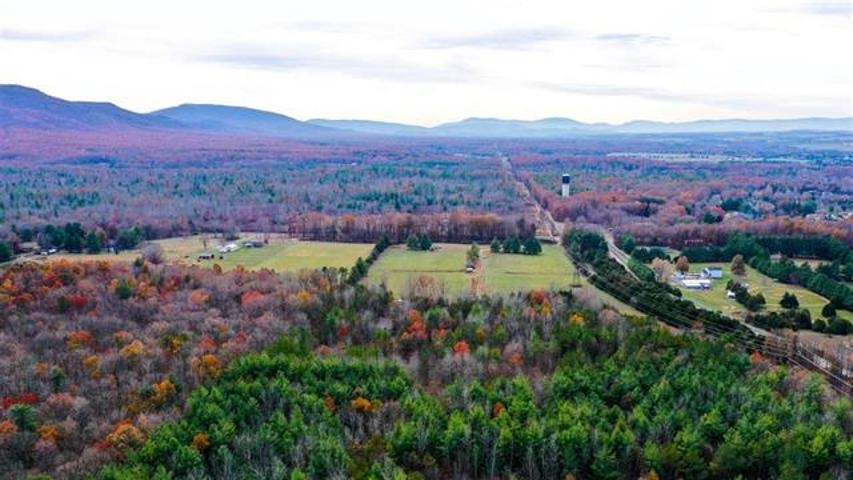 an aerial view of mountain with residential house in background