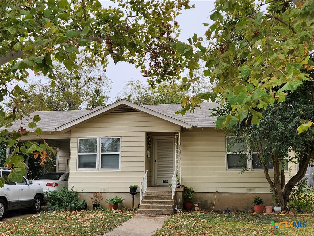 a house that has a tree in front of the house