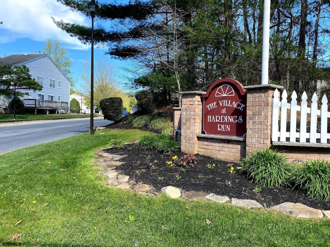 a view of a park that has a sign board large trees