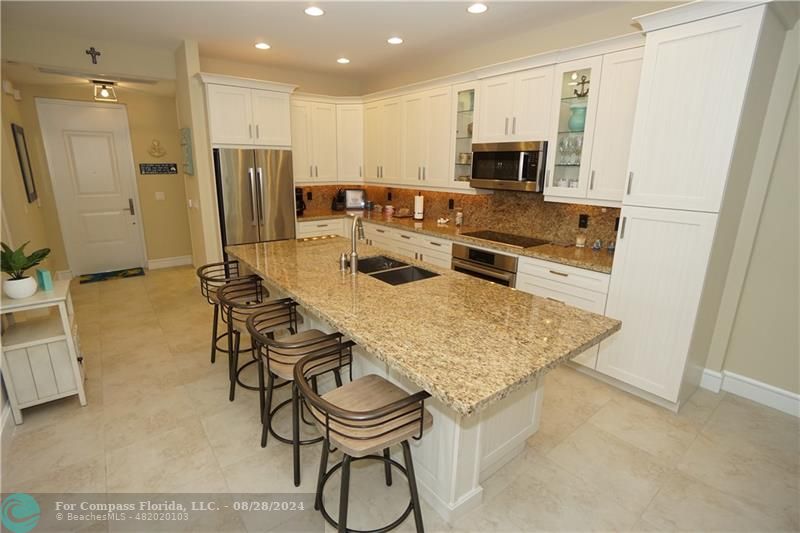 a kitchen with stainless steel appliances granite countertop a stove refrigerator and microwave