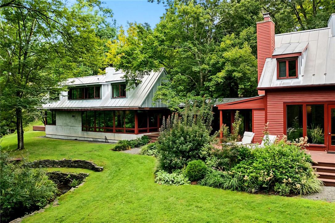 view of the back of the home with many floor to ceiling windows.