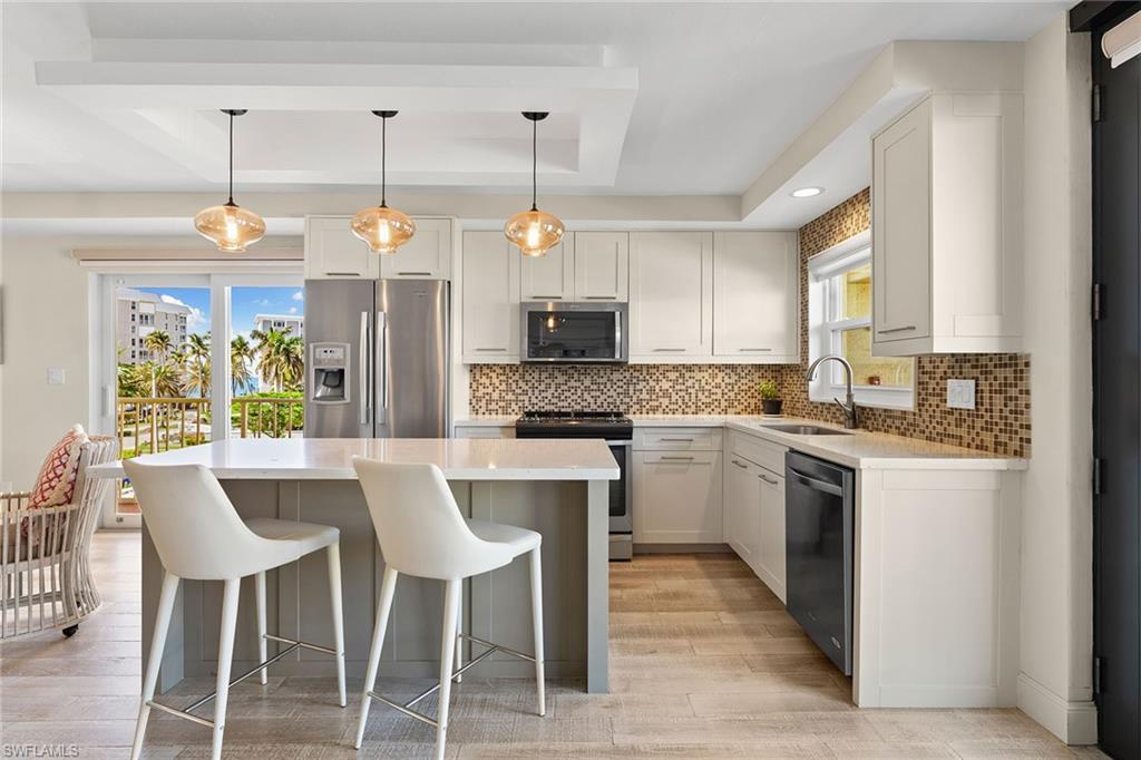 a kitchen with a center island wooden floor cabinets and appliances