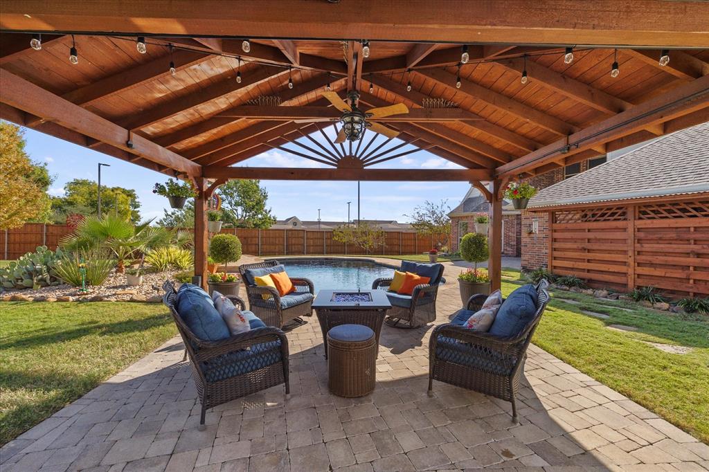 an outdoor sitting area with furniture and umbrella