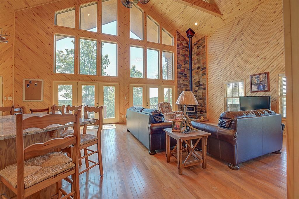 a living room with furniture a large window and wooden floor