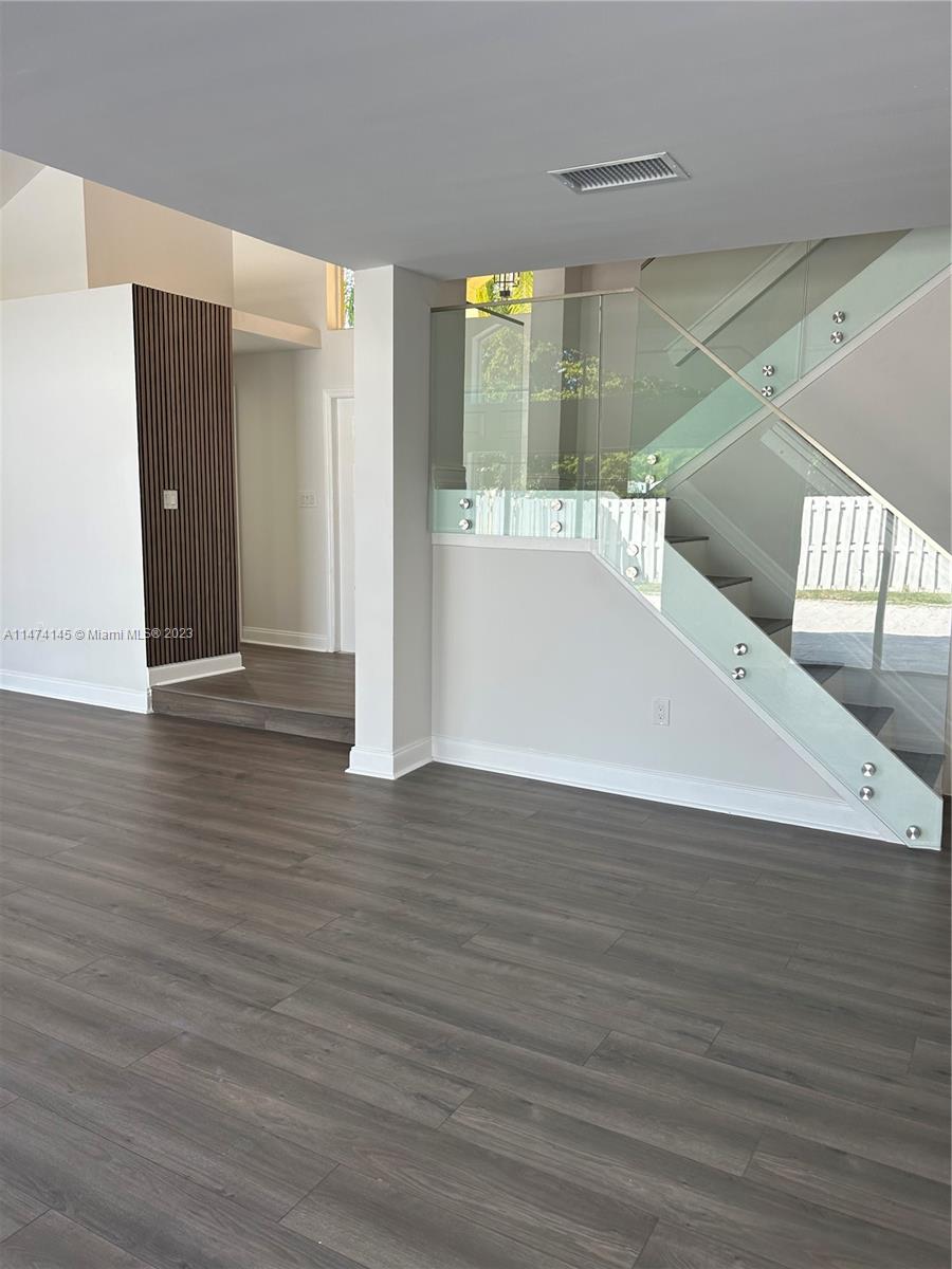 a view of a hallway with wooden floor