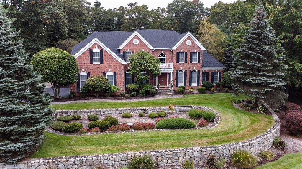 a view of a house with a big yard and large trees