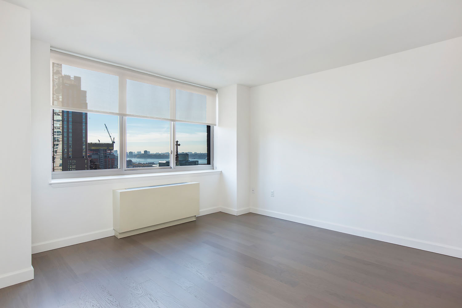 a large white room with wooden floors and white walls