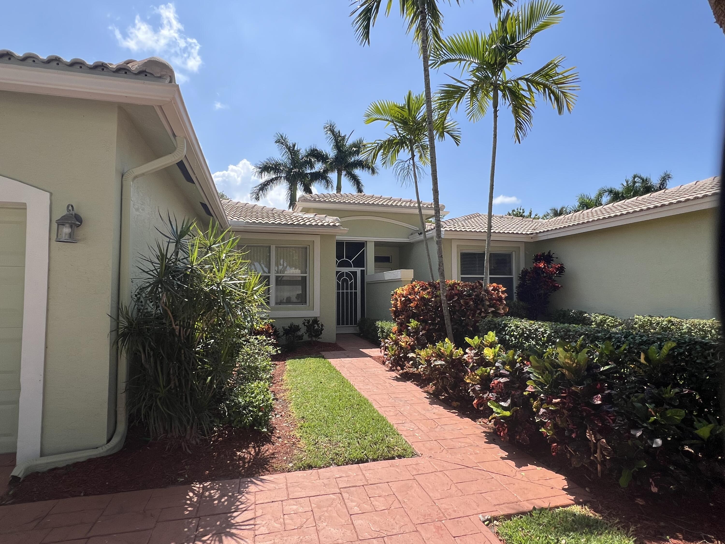 front view of a house with a yard and potted plants