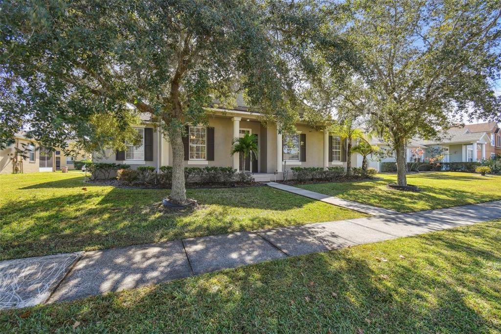 a view of a house with a big yard and large trees