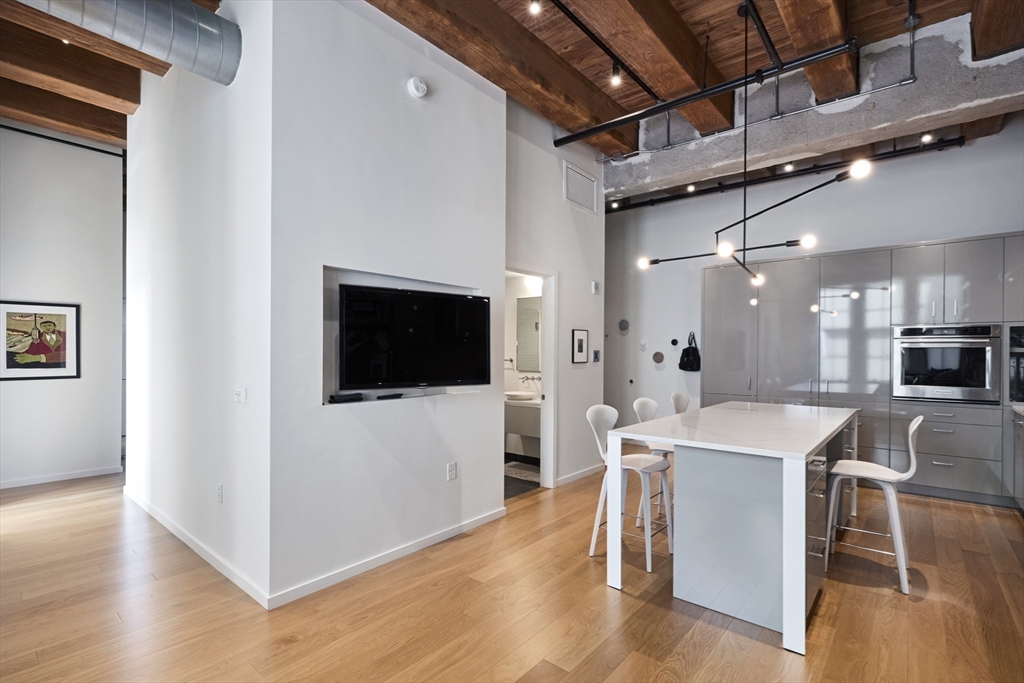 a view of a dining room with furniture wooden floor and a kitchen