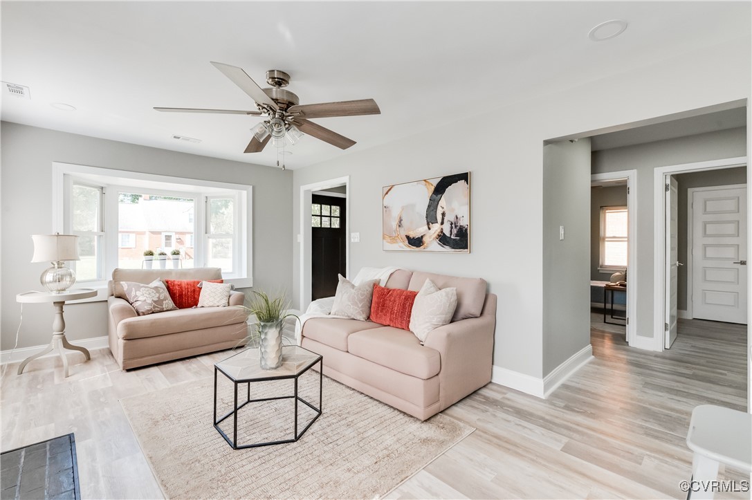 a living room with furniture and a wooden floor