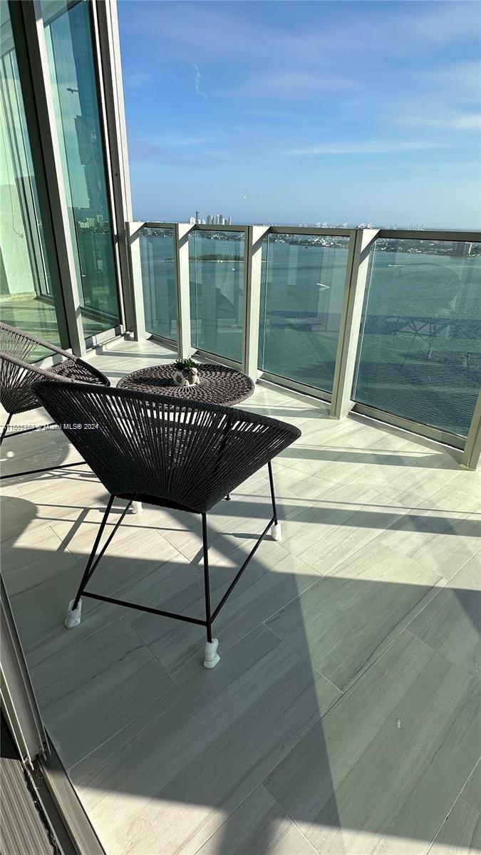 a view of a balcony with floor to ceiling windows and wooden floor