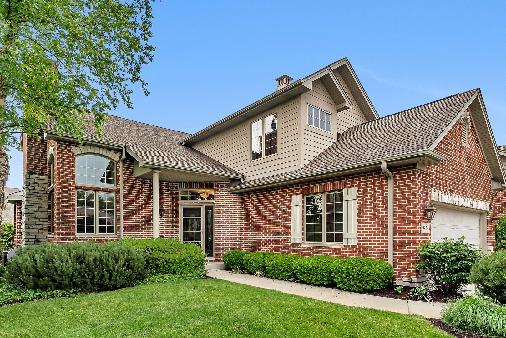 a front view of a house with a yard and garage