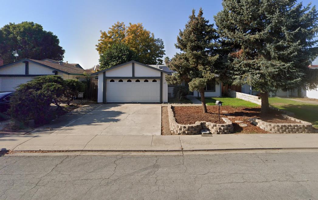 a view of a house with a yard and large tree