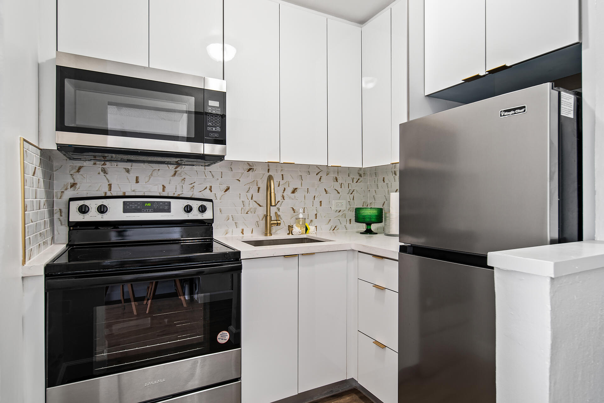 a kitchen with stainless steel appliances a stove microwave and sink