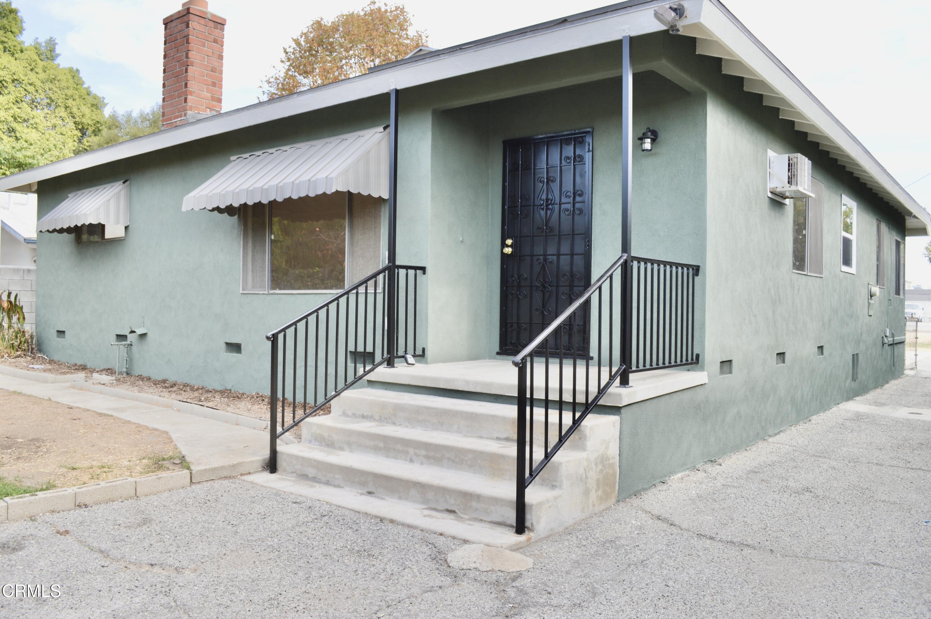 a view of a house with wooden fence and a floor to ceiling window