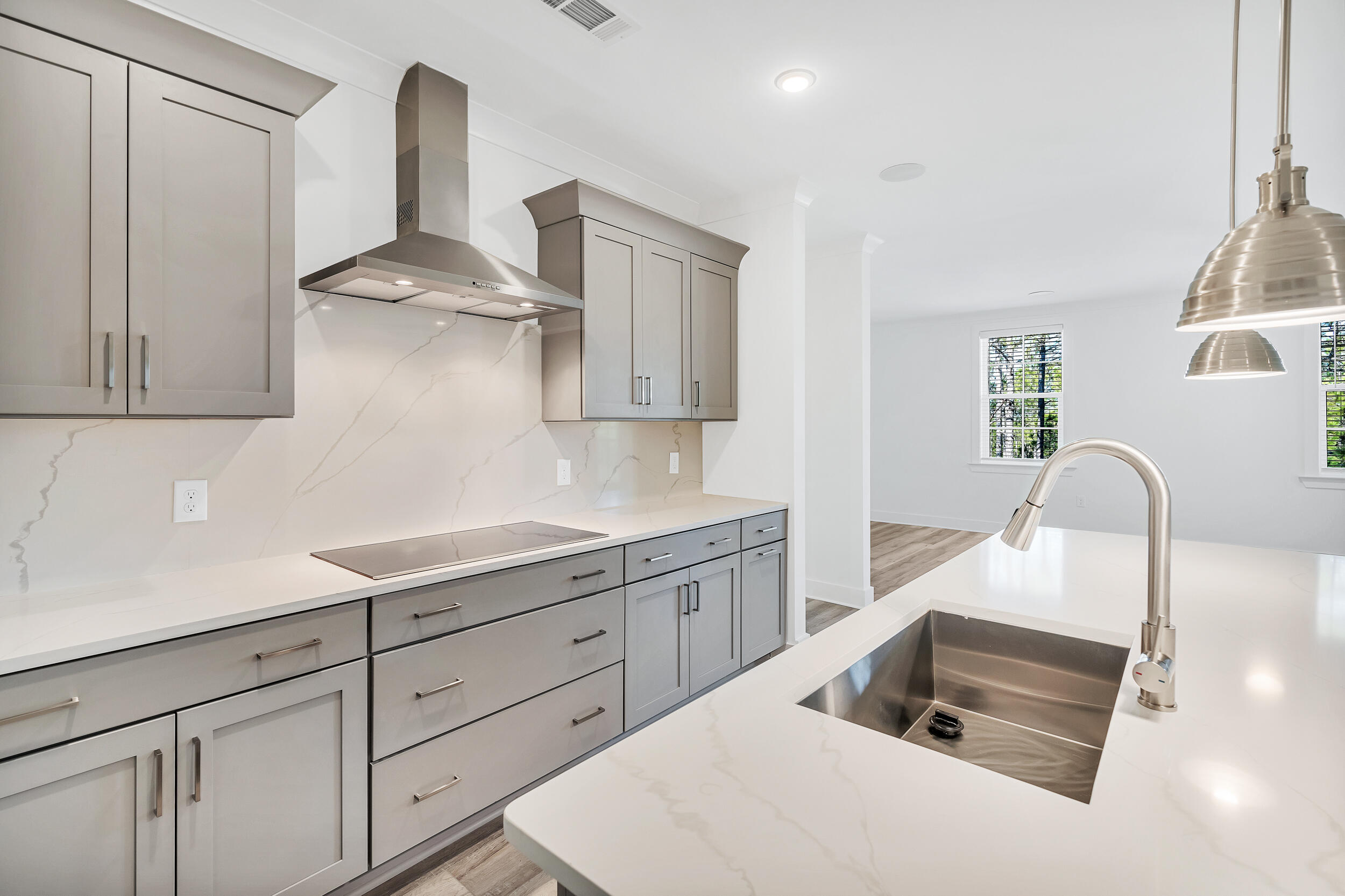 a kitchen with white cabinets and sink