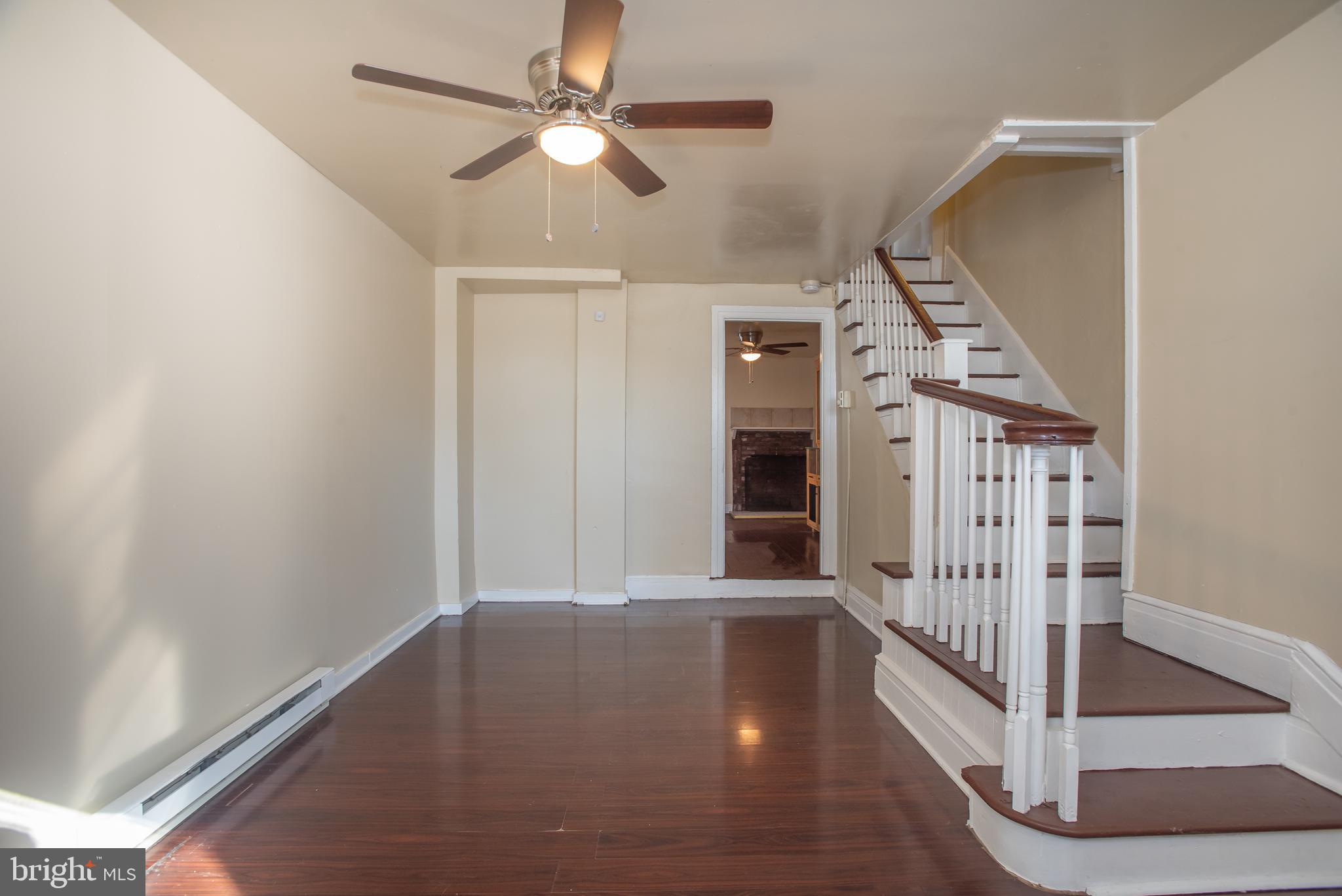 an empty room with windows and ceiling fan