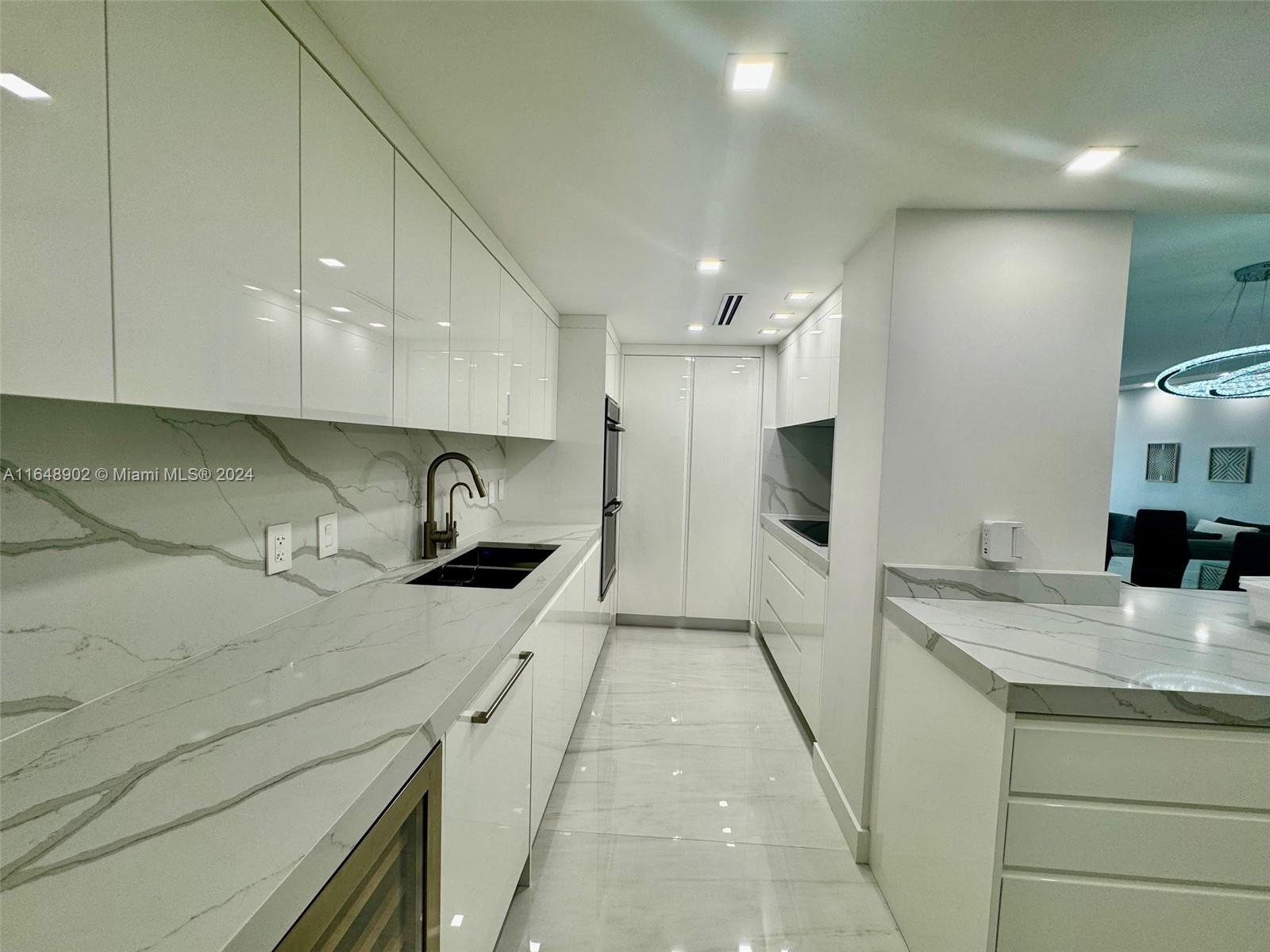 a kitchen with a sink a refrigerator and cabinets