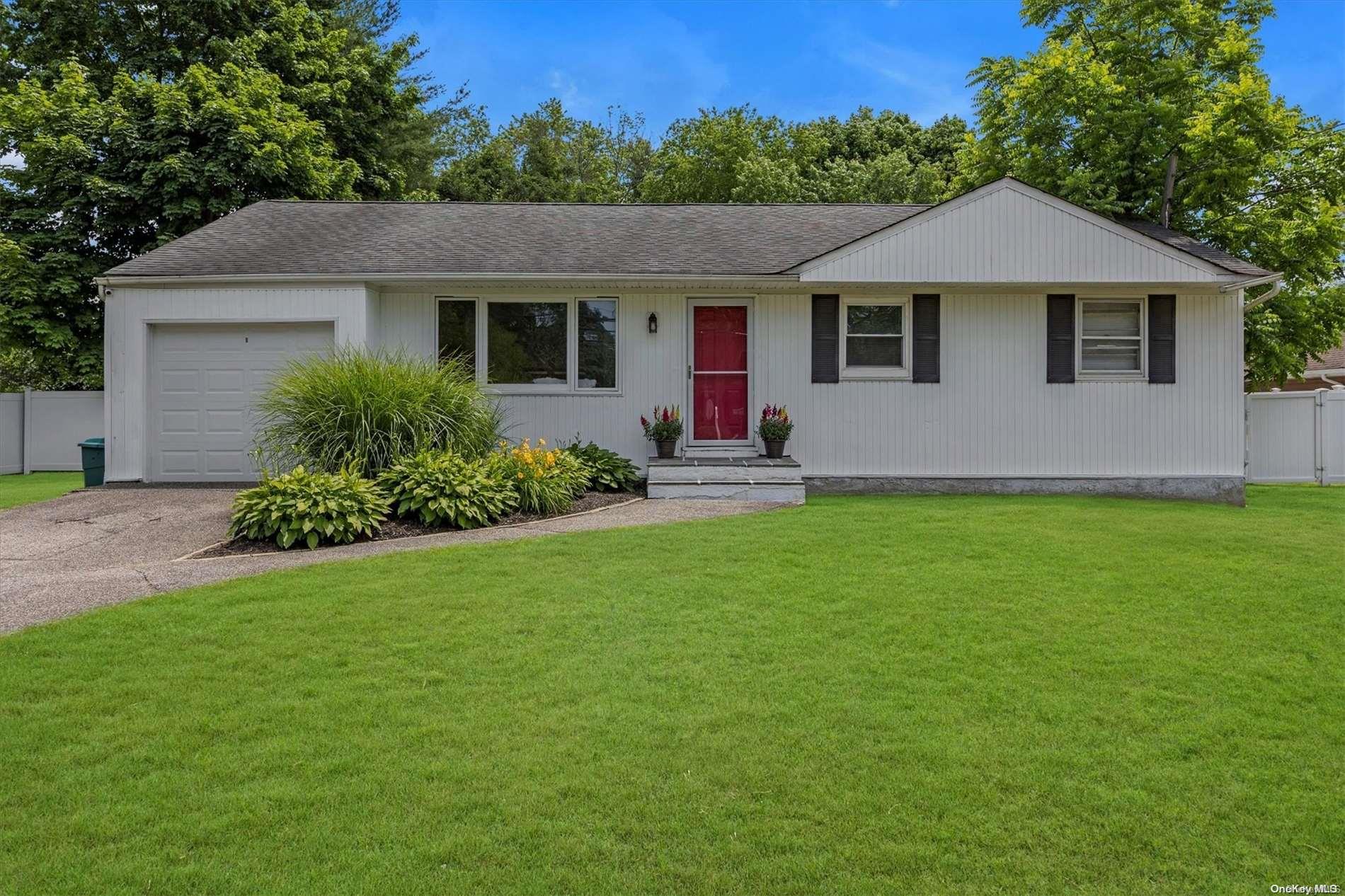 a front view of a house with a garden and yard