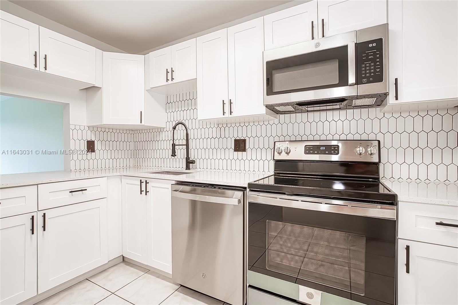 a kitchen with cabinets stainless steel appliances and a sink