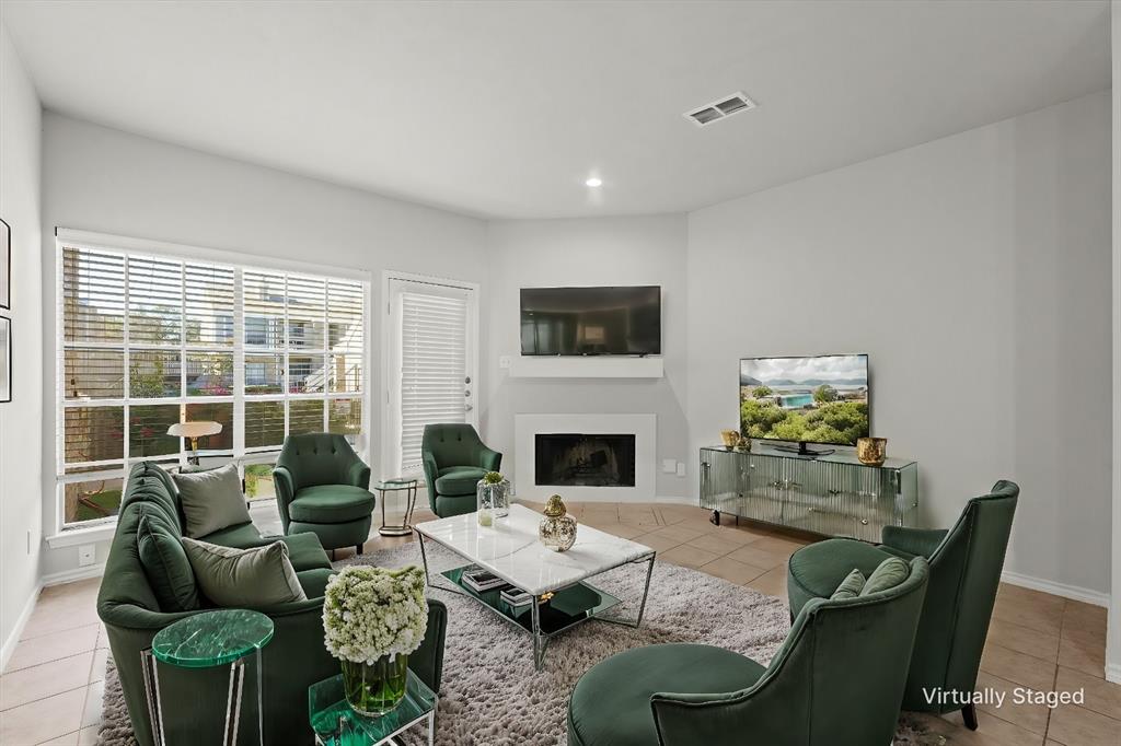 a living room with furniture a fireplace and a large window