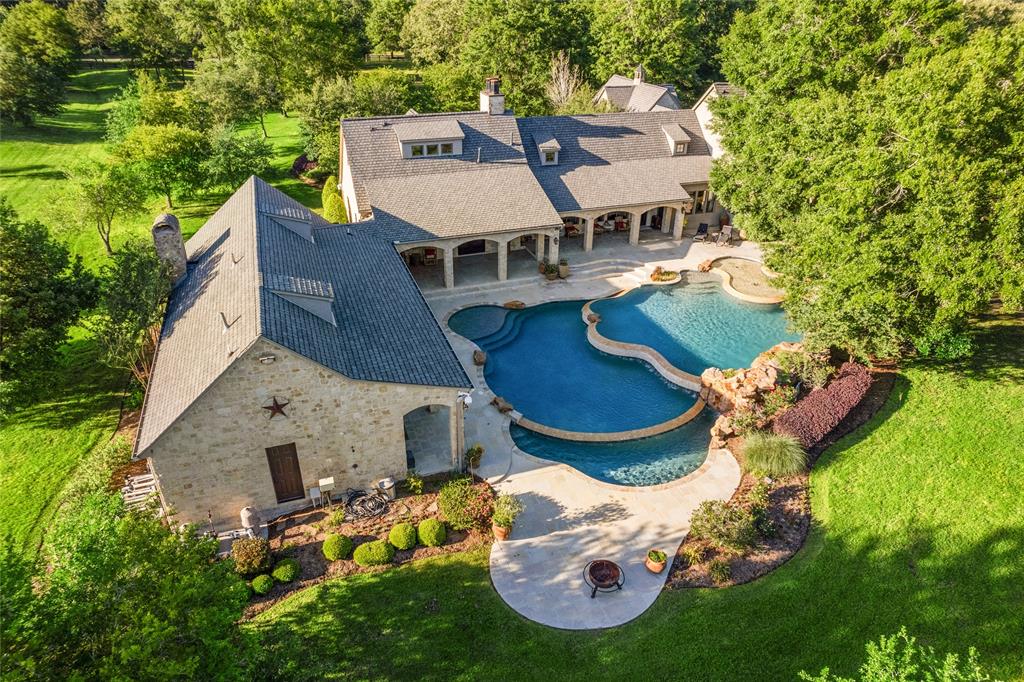 an aerial view of a house with swimming pool garden and patio