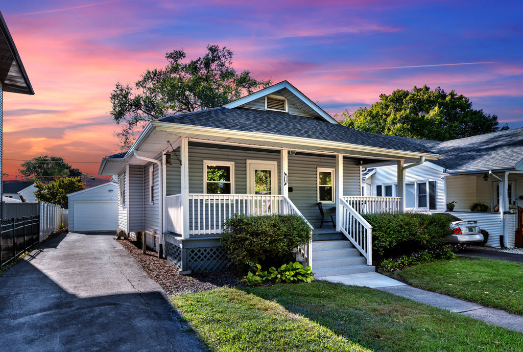 a front view of a house with a yard and potted plants