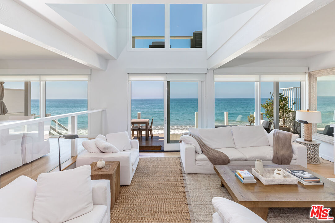 a living room with furniture and floor to ceiling windows