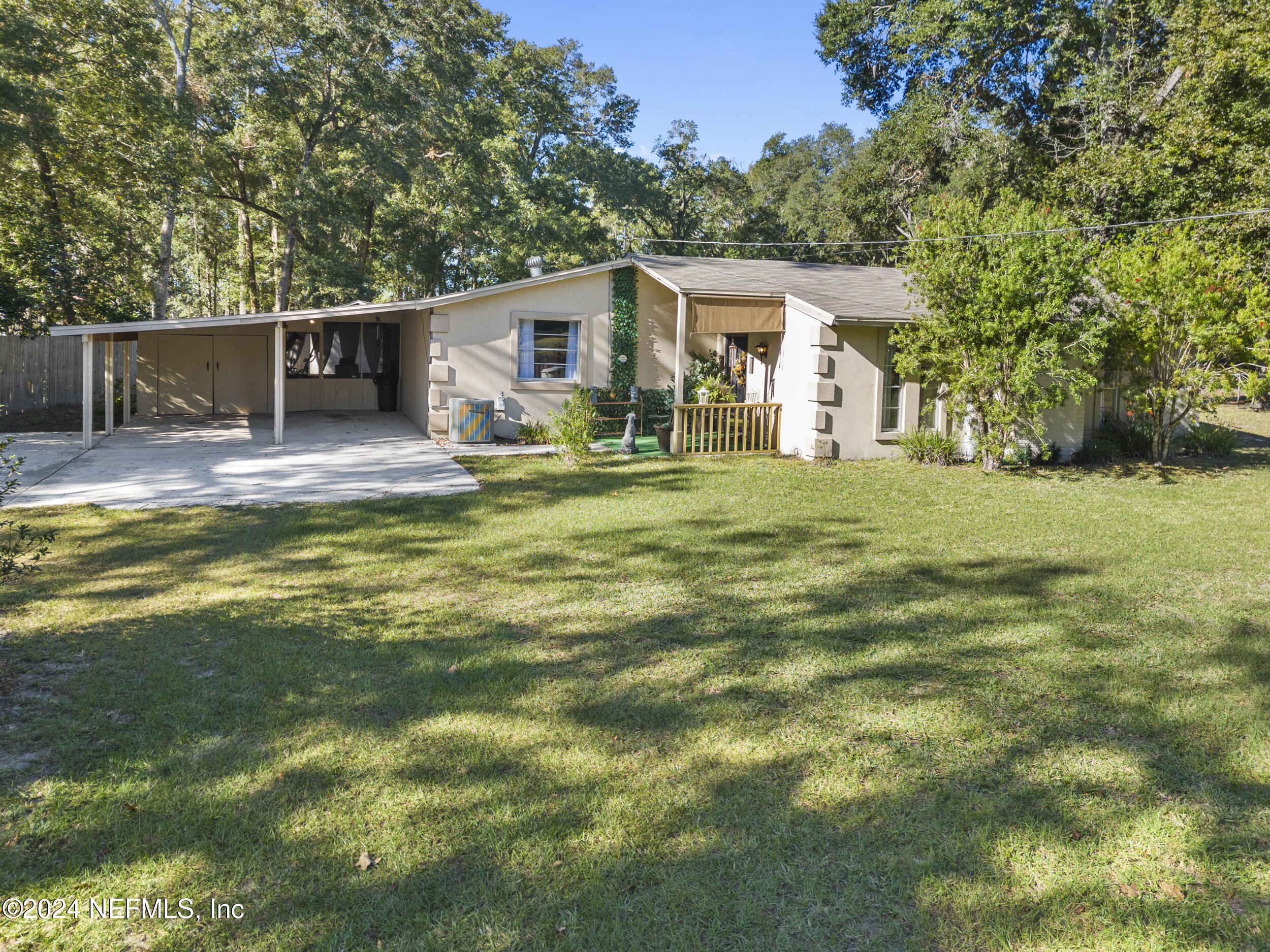 a view of a house with a backyard and a tree