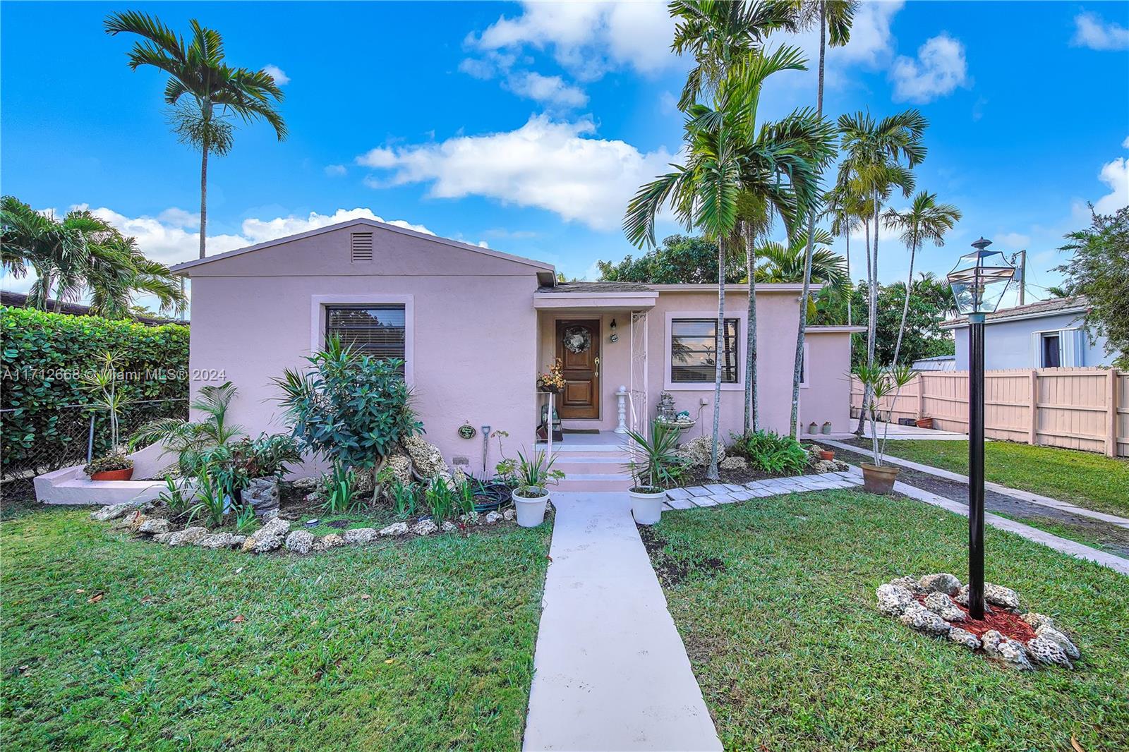 a front view of a house with a yard and potted plants