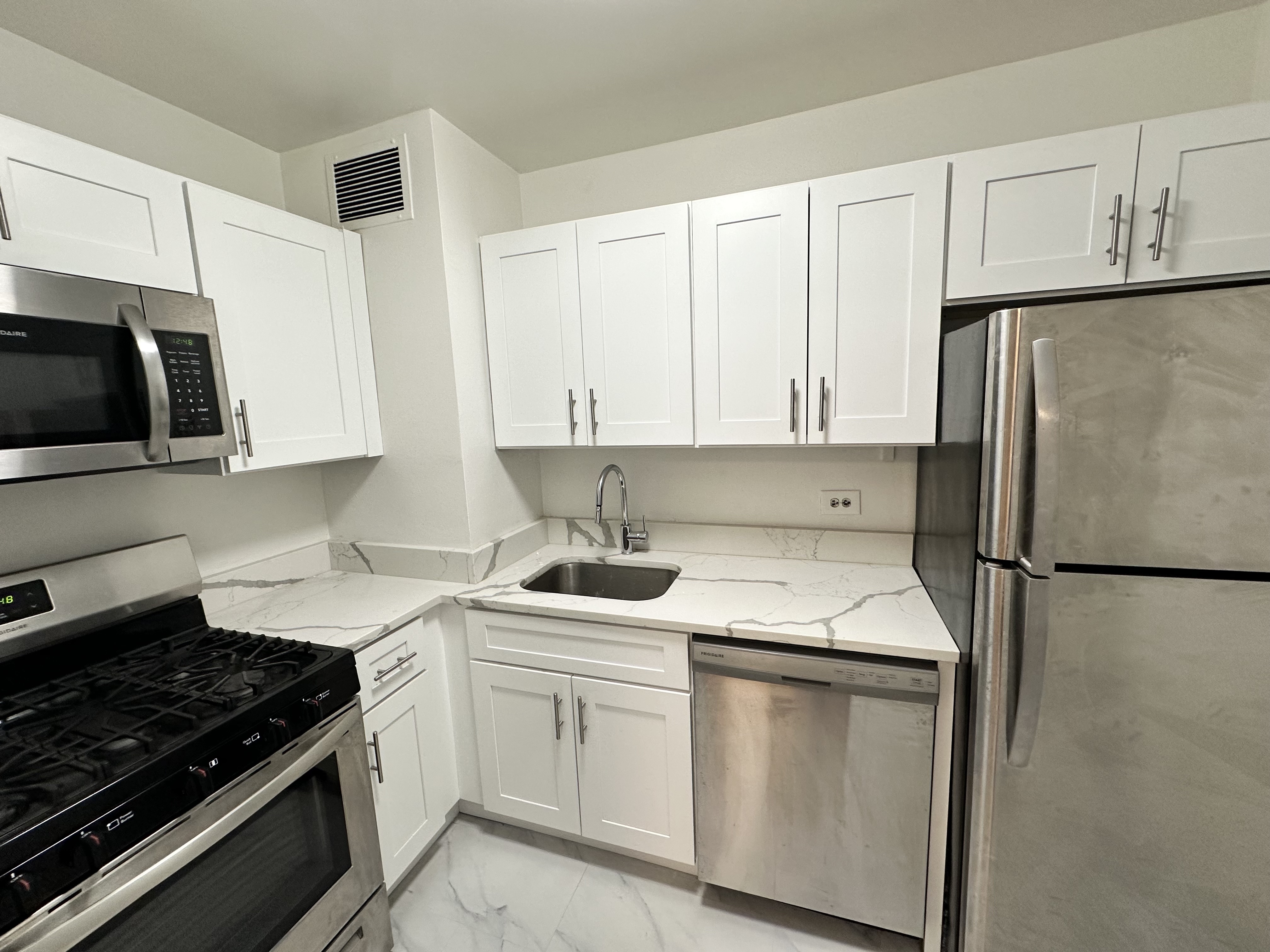 a kitchen with appliances a sink and cabinets