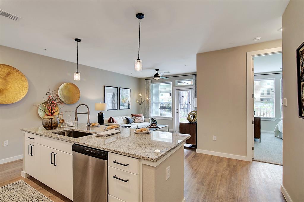 a kitchen with a sink stove and wooden floor