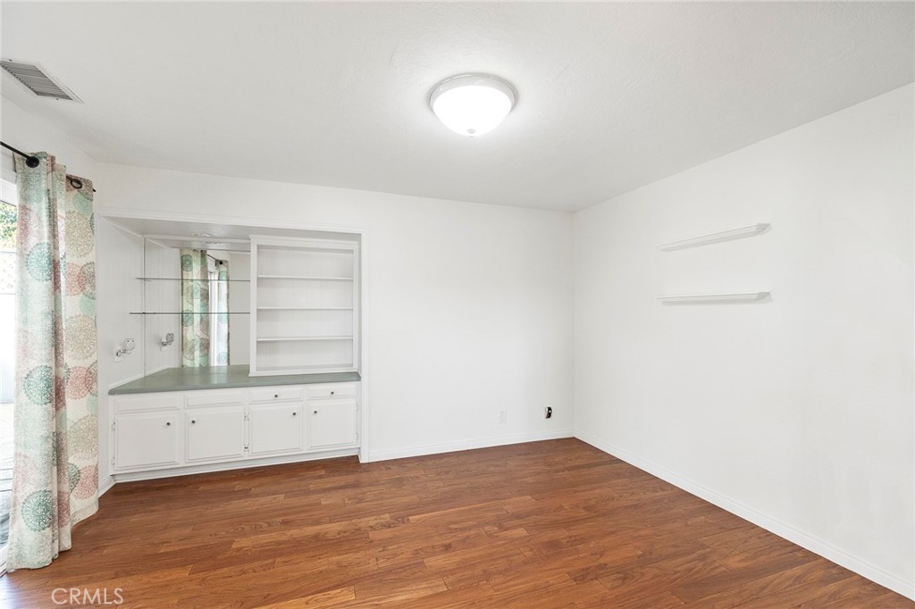 an empty room with cabinet and mirrors